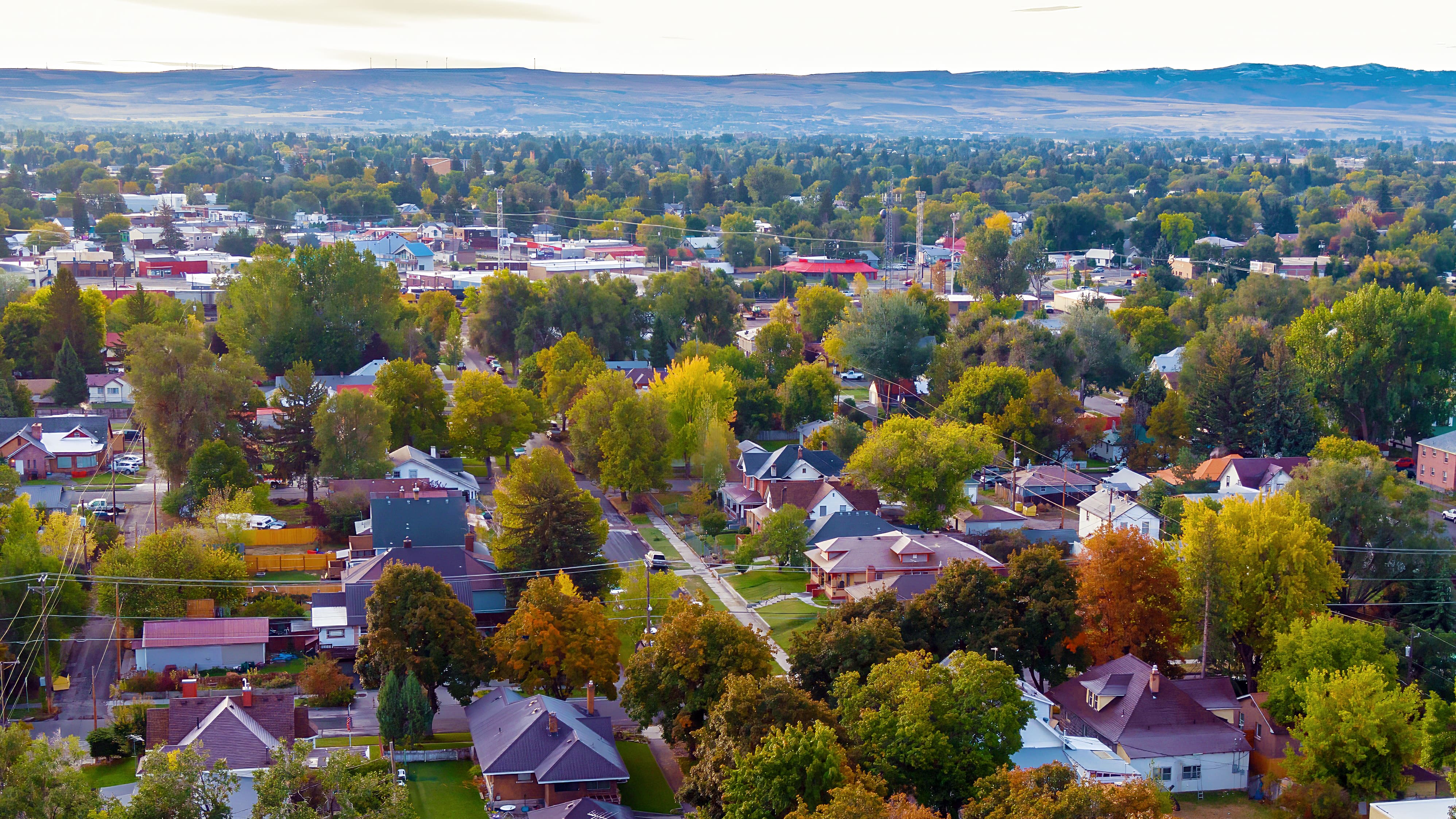 Aerial view of Idaho Falls residential neighborhoods in autumn, showing diverse housing styles and tree-lined streets representing the community residents love